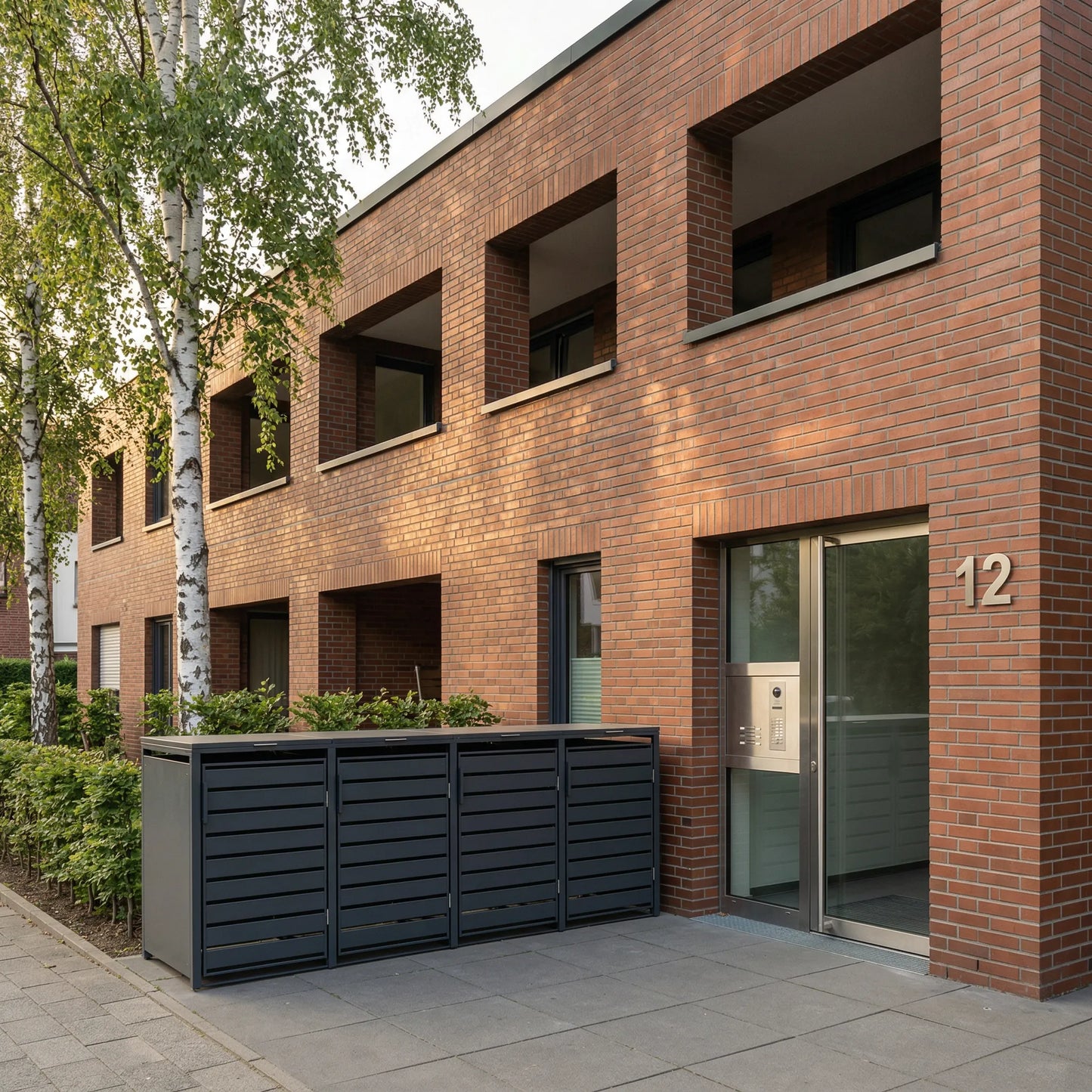 TREVANO 4er anthrazit am Backstein-Mehrfamilienhaus – Birken und Hecke am Eingang